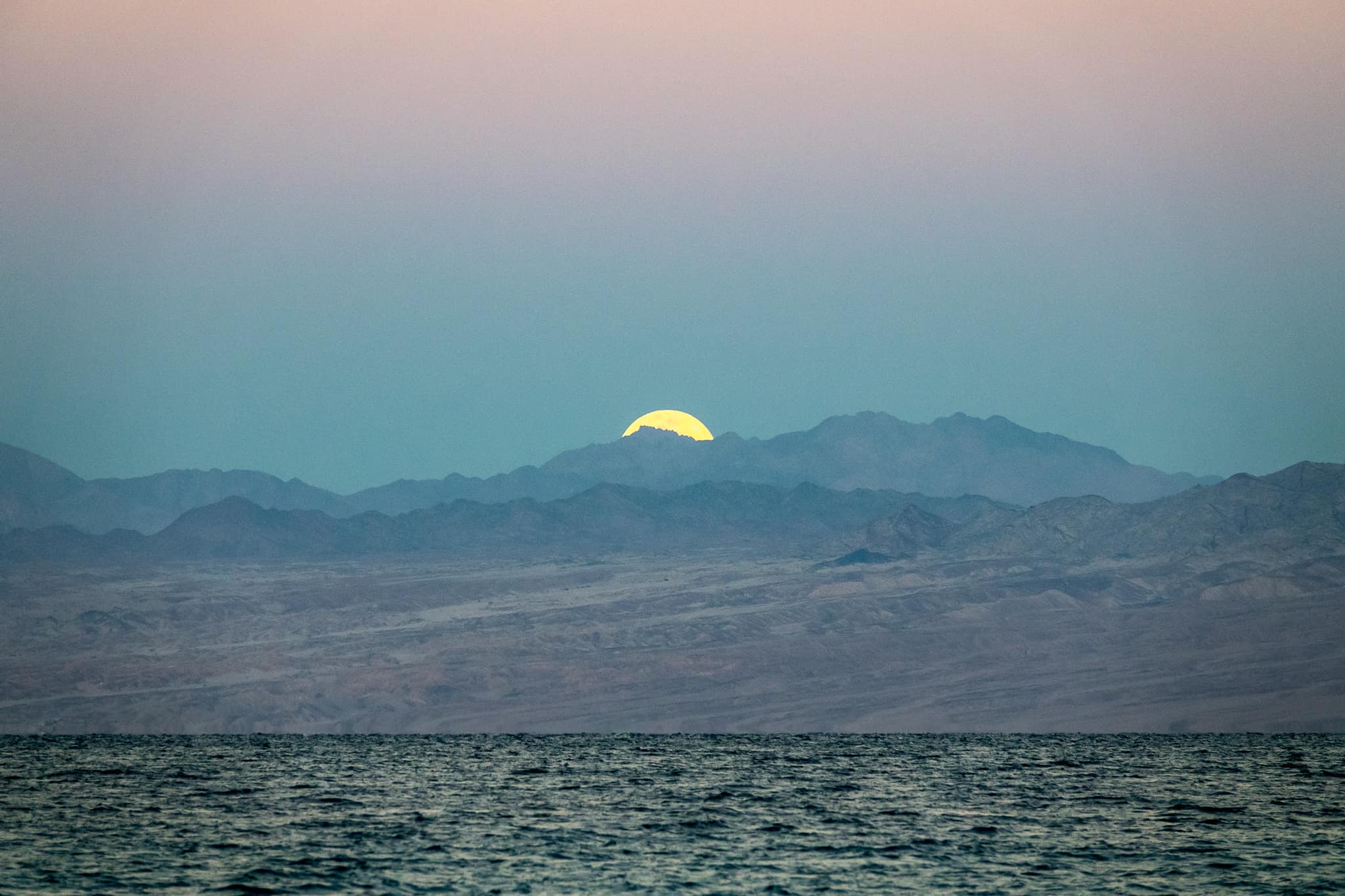 The Supermoon setting over Saudi Arabia, as seen from the Sinai peninsula in egypt