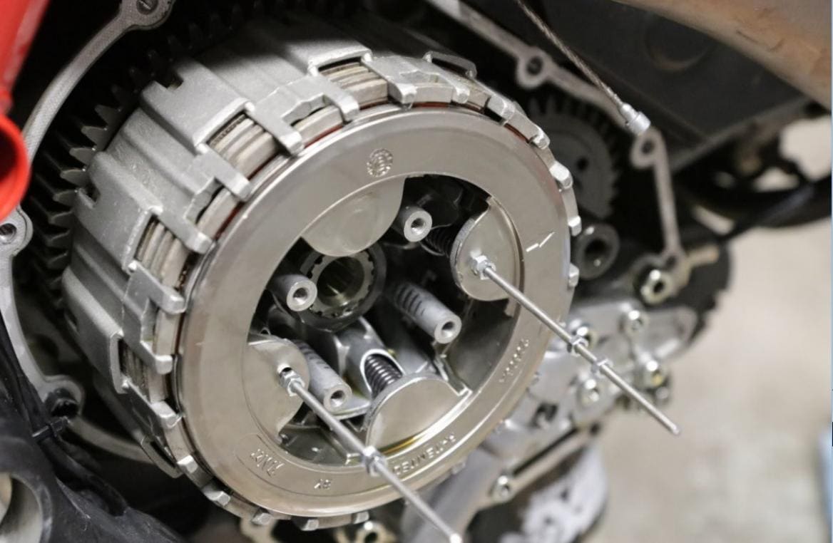 Removing the four bolts holding the clutch springs and pressure plate