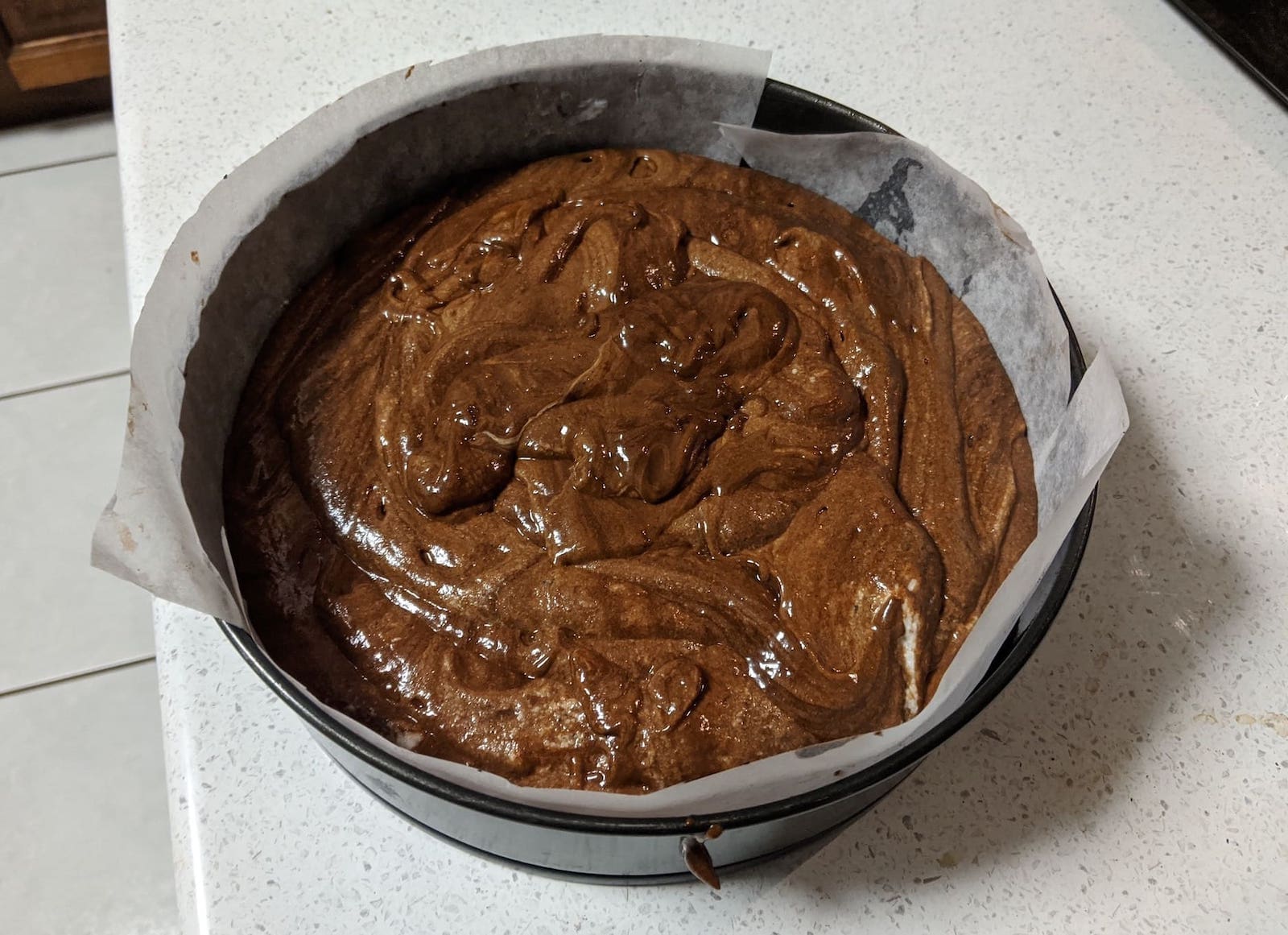 chocolate mousse poured into a tin, ready to become cake